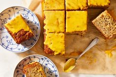 several slices of cake on plates with spoons next to them and another piece is cut into squares