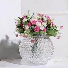 a vase filled with lots of pink and white flowers