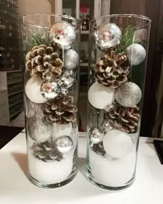 two glass vases filled with ornaments on top of a table