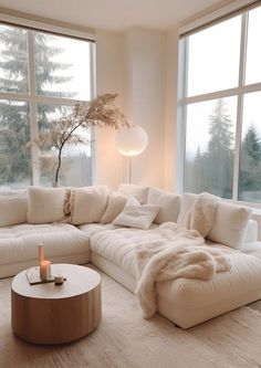 a living room with large windows and a white couch in front of the window is lit by a candle