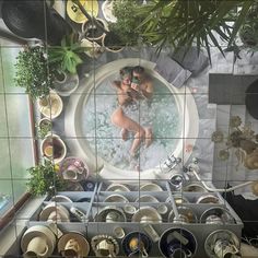 a woman in a bathtub surrounded by pots and pans