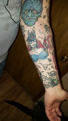 a man's arm with tattoos on it and an image of monsters in the background