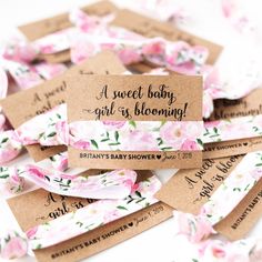 baby shower favors with pink flowers on them and brown tags that say sweet baby girl is blooming