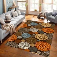 a living room filled with furniture and a rug on top of a hard wood floor