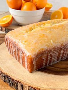 a loaf of bread sitting on top of a wooden cutting board next to oranges