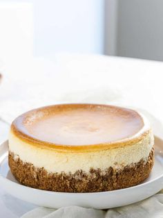 a white plate topped with a cheesecake on top of a table