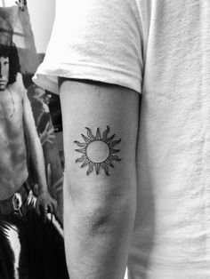 a man with a sun tattoo on his arm