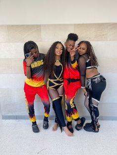 four girls posing for the camera in front of a wall