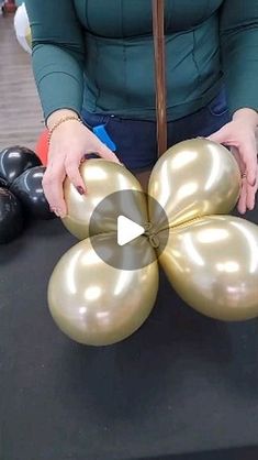 a woman is holding balloons in front of her face