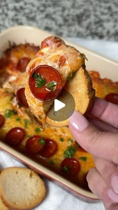 a person is taking a piece of pizza from a casserole dish with bread