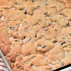 a close up of a cake in a pan on a table with a red and white checkered cloth