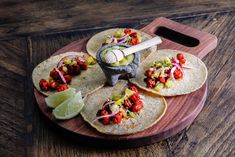 three tortillas on a cutting board with lime wedges and an avocado