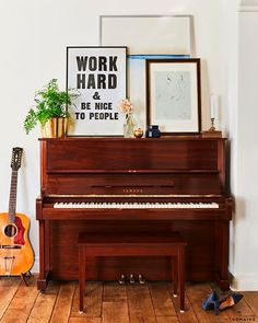 there is a piano and a guitar on the floor in this room with wood floors