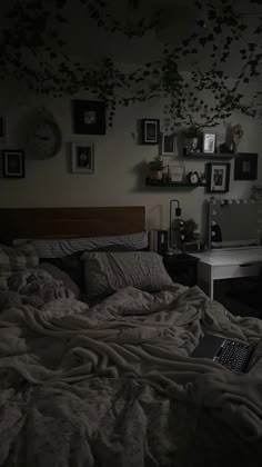 a laptop computer sitting on top of a bed in a room with many framed pictures