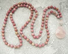 Rhodochrosite Mala Necklace for Women Pinck Beads Long Necklace Rose Quartz Mala Necklace Yoga Jewelry Yoga Gift for Mum Meditation Necklace - 8mm Natural Rhodochrosite Beads - 12mm Rose Quartz Guru Crystal Bead - Rose Quartz Pendant - Neylon Cord ♥ ♥ ♥ ROSE QUARTZ ♥ ♥ ♥ Rose Quartz Crystal is a quartz crystal that derives its name from its lovely rose pink color. These crystals come in a range of beautiful shades of pink. It is known as the 'love stone' as the message it emits is the strong vib Spiritual Pink Beaded Necklaces With Natural Stones, Pink 8mm Beads Jewelry For Meditation, Pink Meditation Necklaces With Round Beads, Rose Quartz Healing Necklace Hand-strung, Hand-strung Rose Quartz Necklaces For Healing, Pink Round Beads Necklace For Meditation, Pink Natural Stones Beaded Necklace For Healing, Handmade Pink Necklaces For Meditation, Handmade Pink Necklace For Meditation