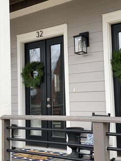 two wreaths on the front porch of a house