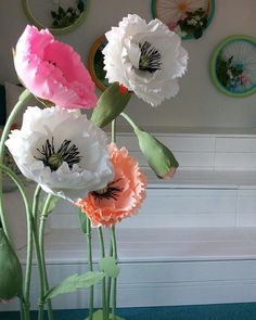 there are three flowers in the vase on the table and one is pink, white and orange