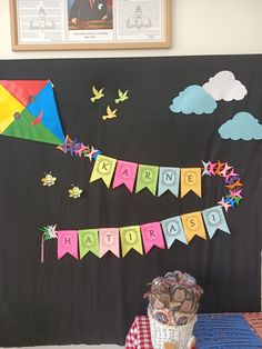 a colorful kite is hanging on the wall next to a basket full of chocolates