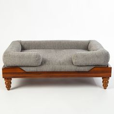 a gray couch sitting on top of a wooden frame