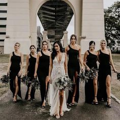 a group of women standing next to each other in front of a tall white building