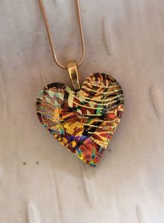 a heart shaped pendant is sitting on a white surface