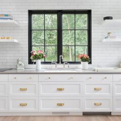 a kitchen with white cabinets and gold handles on the windowsills is pictured in this image