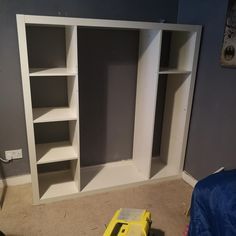 an empty room with shelves and tools in the floor next to a blue bed sheet