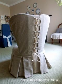 the back of a chair with ruffles on it in a living room area