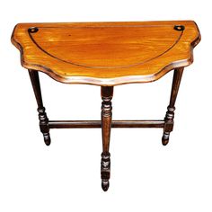 a wooden table with two legs and a curved top on one leg, against a white background