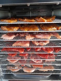 bacon and other meats are cooking in an open oven on the rack, with one being cooked