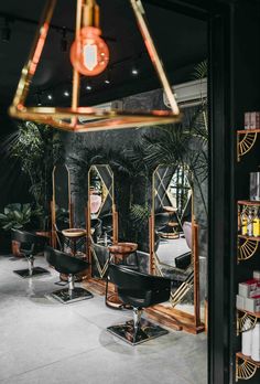 a hair salon with chairs and mirrors in the corner, lights hanging from the ceiling