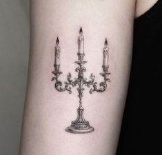 a woman's arm with three candles on it