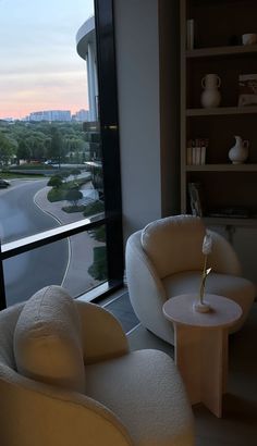 two chairs and a table in front of a window with a view of the street