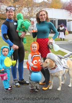 three adults and two children in costumes with a dog