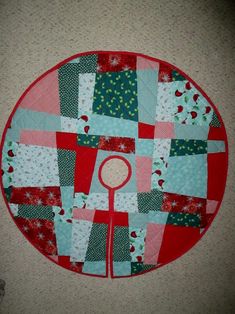 a red and blue patchwork quilted table top with a circular design on it