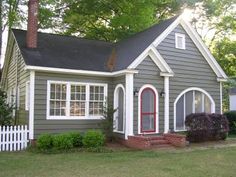 a gray house with white trim and red door