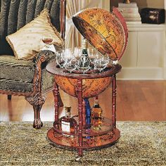 an old world globe sits on top of a small table with liquor bottles and glasses