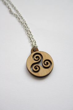 Wooden triskelion necklace with rond shape pendant. Celtic jewellery for man or woman (unisex jewellery). >> Triskele laser cut and laser engraving. This laser cut wooden necklace is made for a woman or man. Made in France, hand made in France (in French Brittany). >> Celtic inspiration. Traditional jewellery.  Wooden pendant measures approximately 2 cm (diameter) = 0,78 inches (diameter). Natural wood : alder. Wood thickness : 3 mm = 0,11 inches. Metal silver color chain 40 cm = 15,74 inches in Laser Cut Wood Pendant Necklace, Triskelion Necklace, French Brittany, Wood Jewelery, Necklace Wood, Woman Jewelry, Wooden Necklace, Wood Necklace, Wooden Pendant