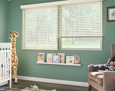 a baby's room with a giraffe stuffed animal in the crib