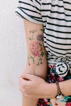 a woman's arm with flowers on it and the words, no mellies ides de tatouge pivoine pour simpsonpier