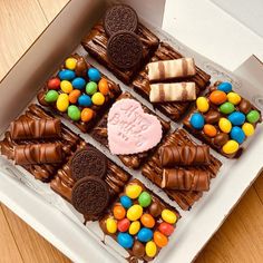 a box filled with lots of different types of candy on top of a wooden table