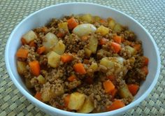 a bowl filled with meat and vegetables on top of a woven tablecloth covered floor