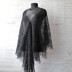 Perfect for a Gothic wedding or any formal affair, this black lace shawl is made from luxurious wool that offers both warmth and a soft, comforting feel against the skin.  Black shawl wrap has length 26,3" (67 cm) and width 90,5" (230 cm) If merino wool causes you allergies or skin discomfort, please let me know and I will make the shawl from organic cotton or linen yarn It's versatile design allows it to be draped elegantly over the shoulders, adding an element of drama and sophistication to an Black Lace Shawl, Elegant One Size Shawl Poncho, Elegant One-size Shawl Poncho, Elegant One-size Cape Shawl, Elegant Black Evening Shawl, One Size Lace Shawl, Elegant Black One-size Shawl, Elegant One-size Lace Shawl, Elegant One Size Lace Shawl