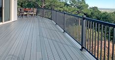 a deck with table and chairs overlooking the trees