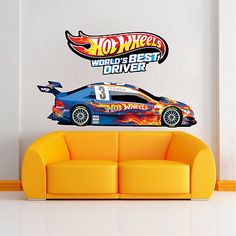 a couch sitting in front of a wall with a hot wheels decal on it