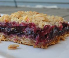 a close up of a piece of food on a plate with fruit and oatmeal crumbs