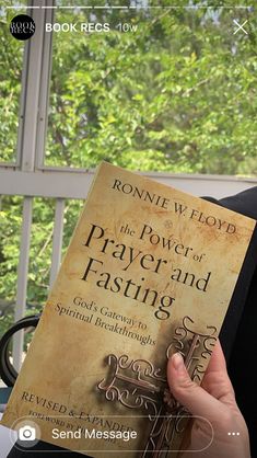 a person holding up a book in front of a window with the words, the power of prayer and fasting