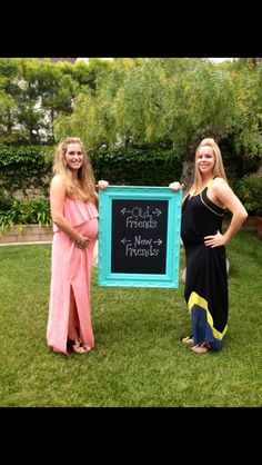 two women standing next to each other in front of a chalkboard sign that says follow your new friends