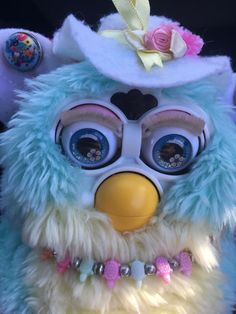 a close up of a stuffed animal with big eyes and a hat on it's head