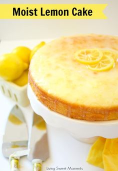 a lemon cake sitting on top of a white plate with lemons next to it